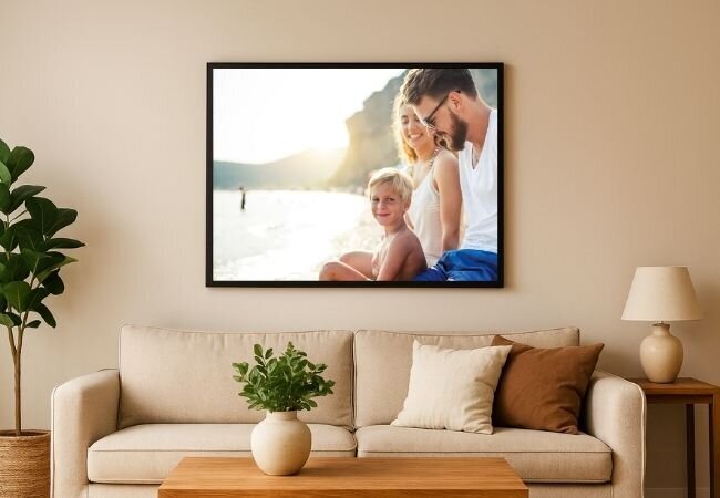 Two beautifully framed canvas prints hanging on a wall over a desk. On the left canvas is a family playing outside together with a beautiful sunset behind. The Canvas on the right is a father holding his daughter's hand as he walks her to school. 