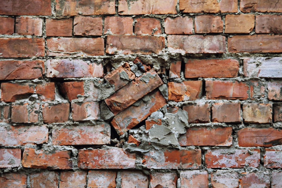 A brick wall that is very poorly repaired.